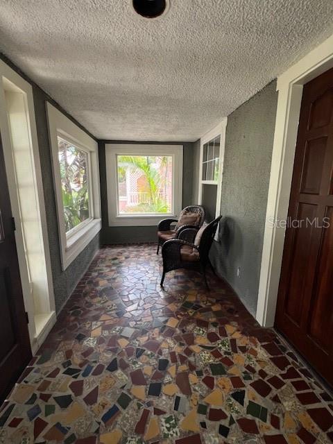 A sunroom features a multi-colored mosaic tile floor, large windows, and two wicker chairs — 4748 7TH AVENUE N, ST PETERSBURG, FL