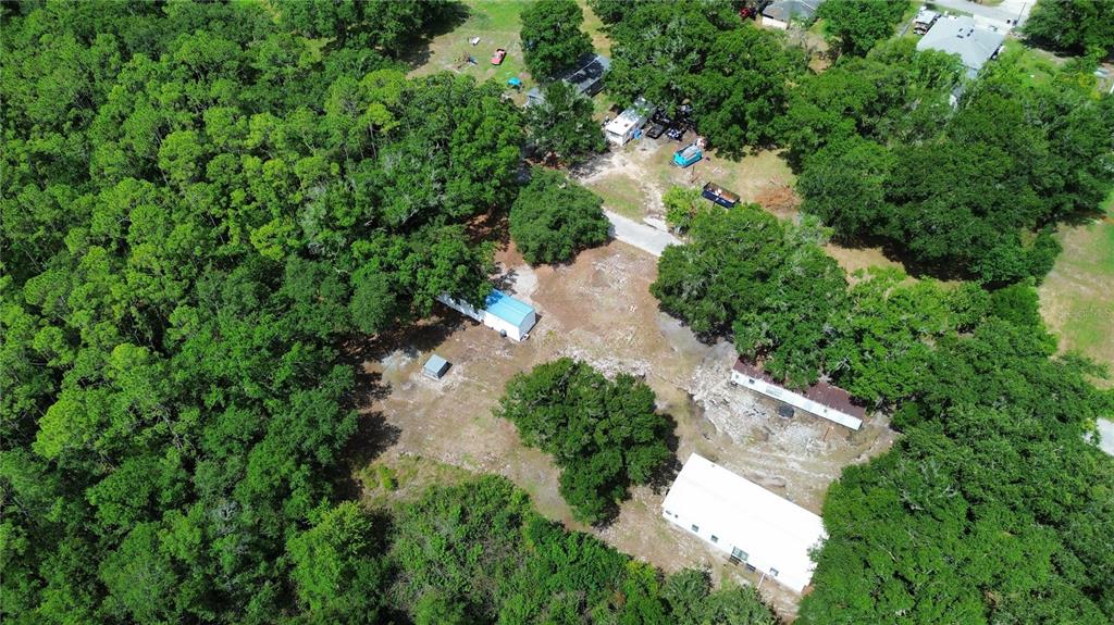 An aerial view shows several buildings and mobile homes situated on a wooded, rural lot — 2204 SHIRAH ROAD, AUBURNDALE, FL