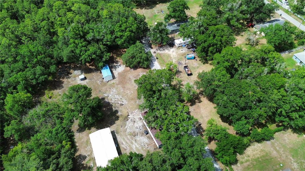 An aerial view shows a wooded property with several buildings, outbuildings, and a gravel driveway — 2204 SHIRAH ROAD, AUBURNDALE, FL