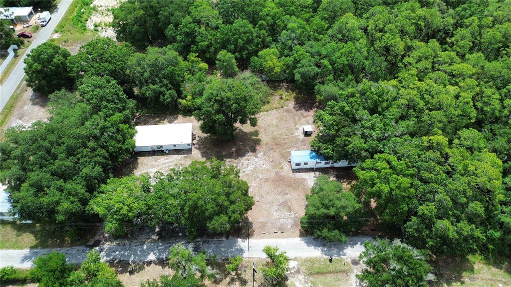 An aerial view shows two mobile homes situated on a wooded lot with gravel driveways — 2204 SHIRAH ROAD, AUBURNDALE, FL