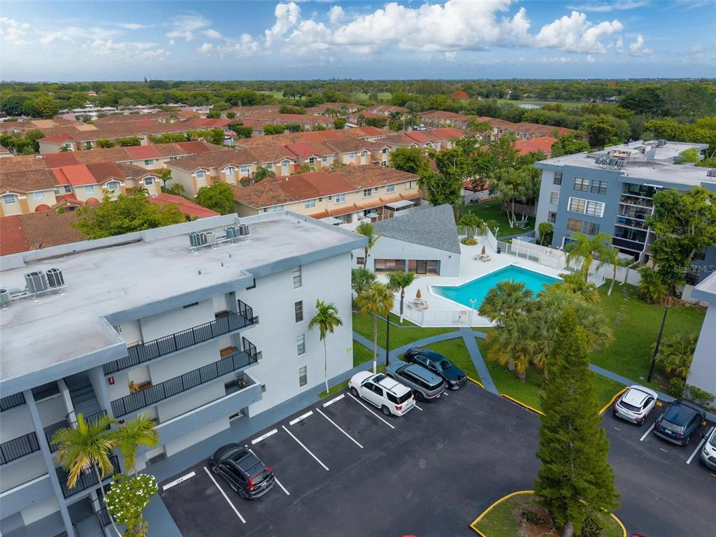 An aerial view shows a multi-story apartment building, a swimming pool, and a parking lot — 13870 SW 62ND STREET UNIT 210, MIAMI, FL