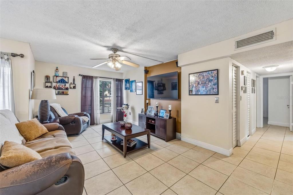 A living room features tile floors, a ceiling fan, a television, and a coffee table — 13870 SW 62ND STREET UNIT 210, MIAMI, FL