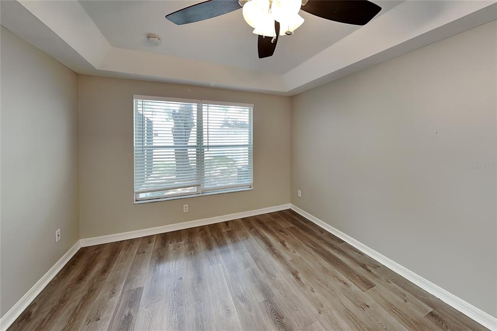 An empty room with light-colored walls, wood-look flooring, a ceiling fan, and a window — 32437 FISH HOOK LOOP, WESLEY CHAPEL, FL