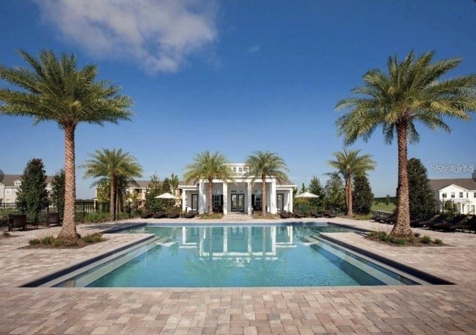 A swimming pool sits in front of a white clubhouse building with palm trees — 15349 SHONAN GOLD DRIVE, WINTER GARDEN, FL