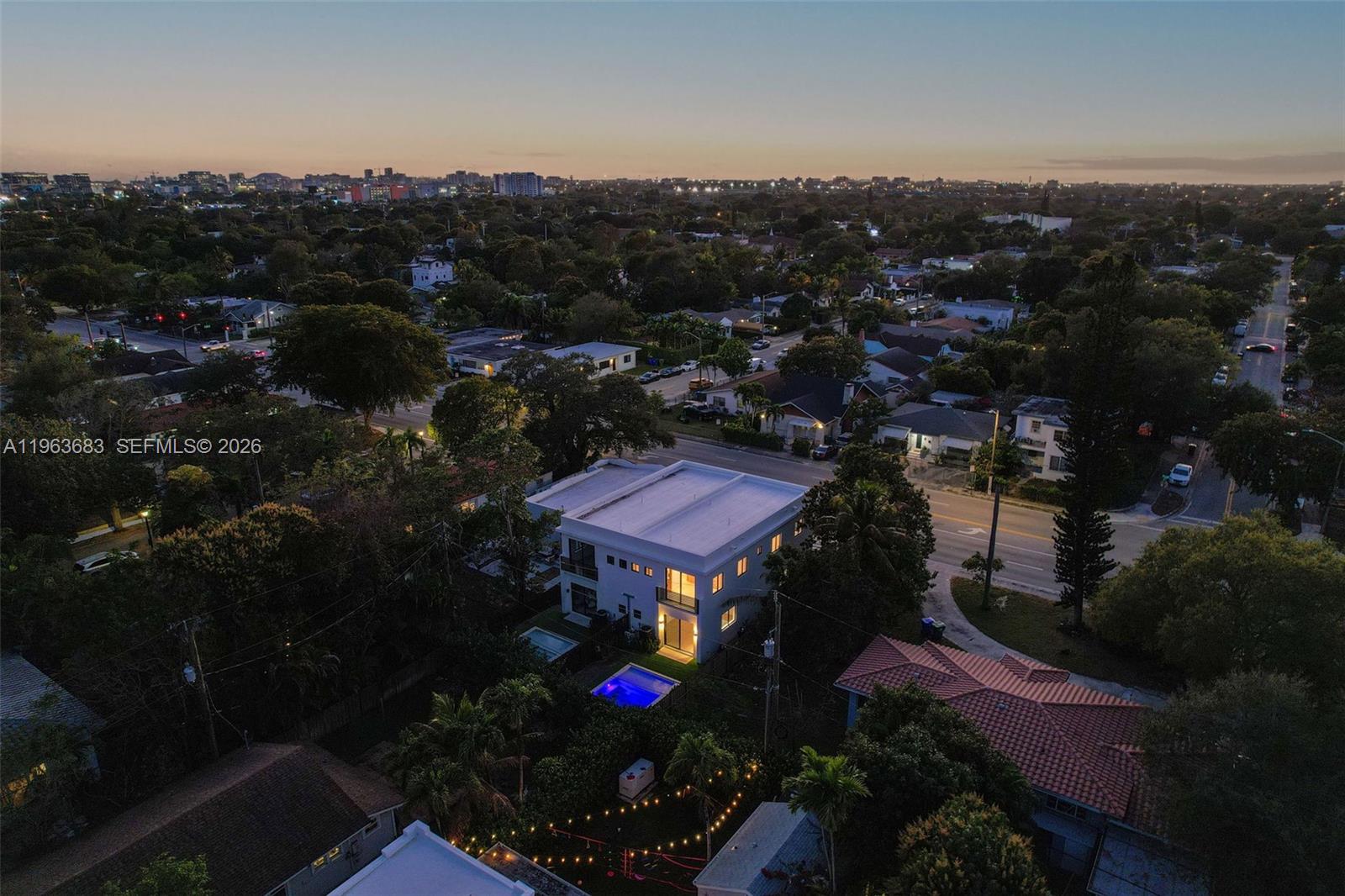 An aerial view shows a modern white house with a pool at dusk — 4719 N Miami Ave, Miami FL 33127, MIAMI, FL