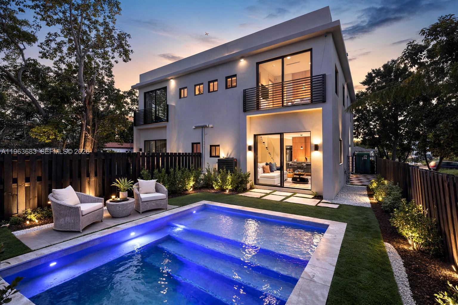 A modern two-story house features a backyard pool, patio seating, and a wooden privacy fence — 4719 N Miami Ave, Miami FL 33127, MIAMI, FL