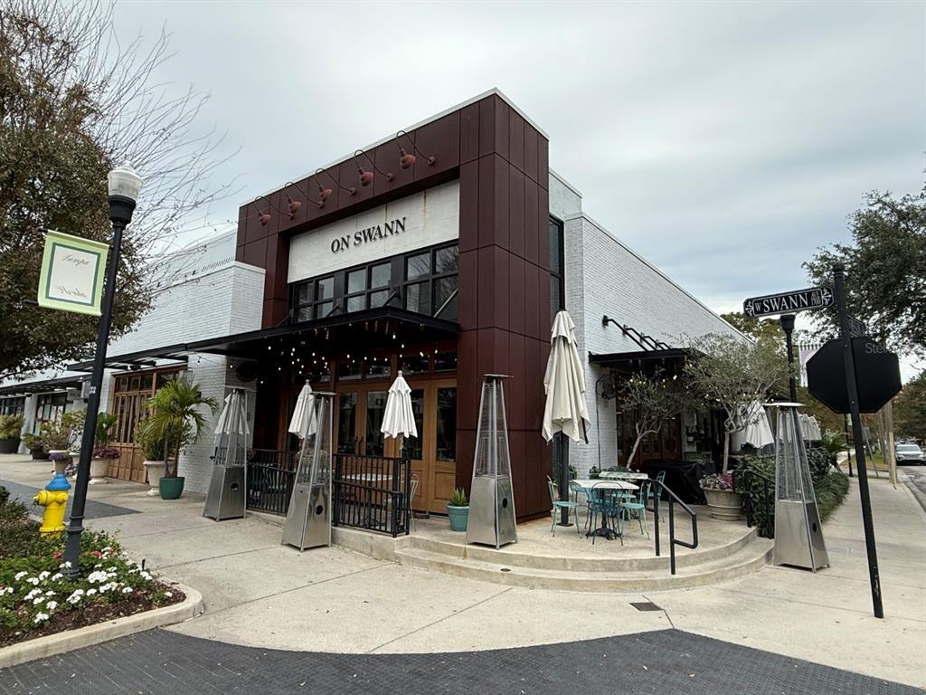 A restaurant exterior features a white brick facade with a dark brown entrance and patio — 1715 W CARMEN STREET, TAMPA, FL