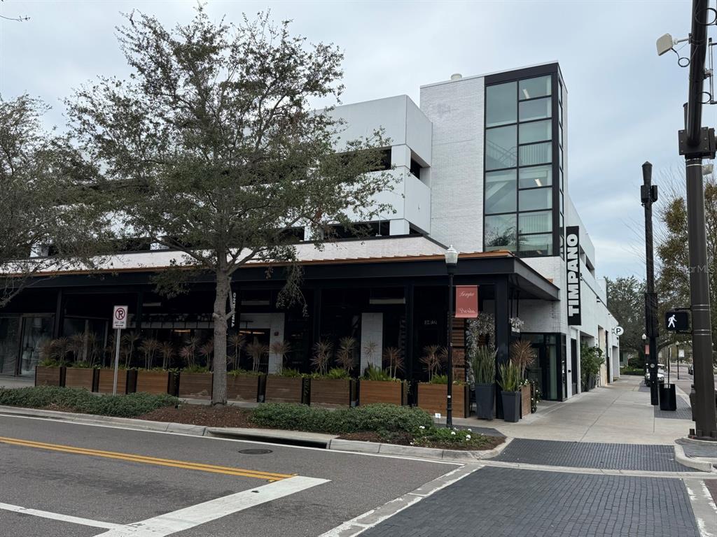 A street-level view of the Timpano restaurant exterior with a multi-level parking garage above — 1715 W CARMEN STREET, TAMPA, FL