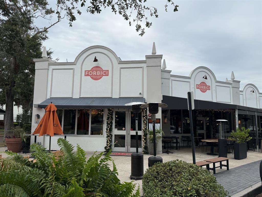 The exterior of a white commercial building with a restaurant entrance and outdoor patio seating — 1715 W CARMEN STREET, TAMPA, FL