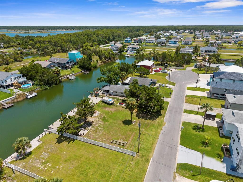 An aerial view shows a waterfront residential lot with a house, lawn, and canal — 0 SEA GRAPE DR Lots 19 and 20, HERNANDO BEACH, FL