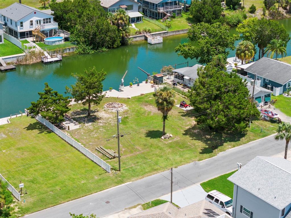 An aerial view shows a vacant waterfront lot with a palm tree and fire pit — 0 SEA GRAPE DR Lots 19 and 20, HERNANDO BEACH, FL
