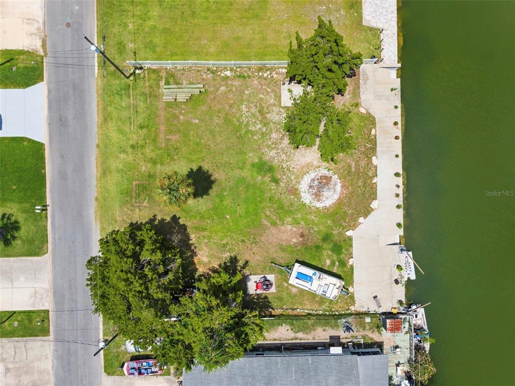 An aerial view shows a waterfront lot with a concrete seawall, trees, and a trailer — 0 SEA GRAPE DR Lots 19 and 20, HERNANDO BEACH, FL