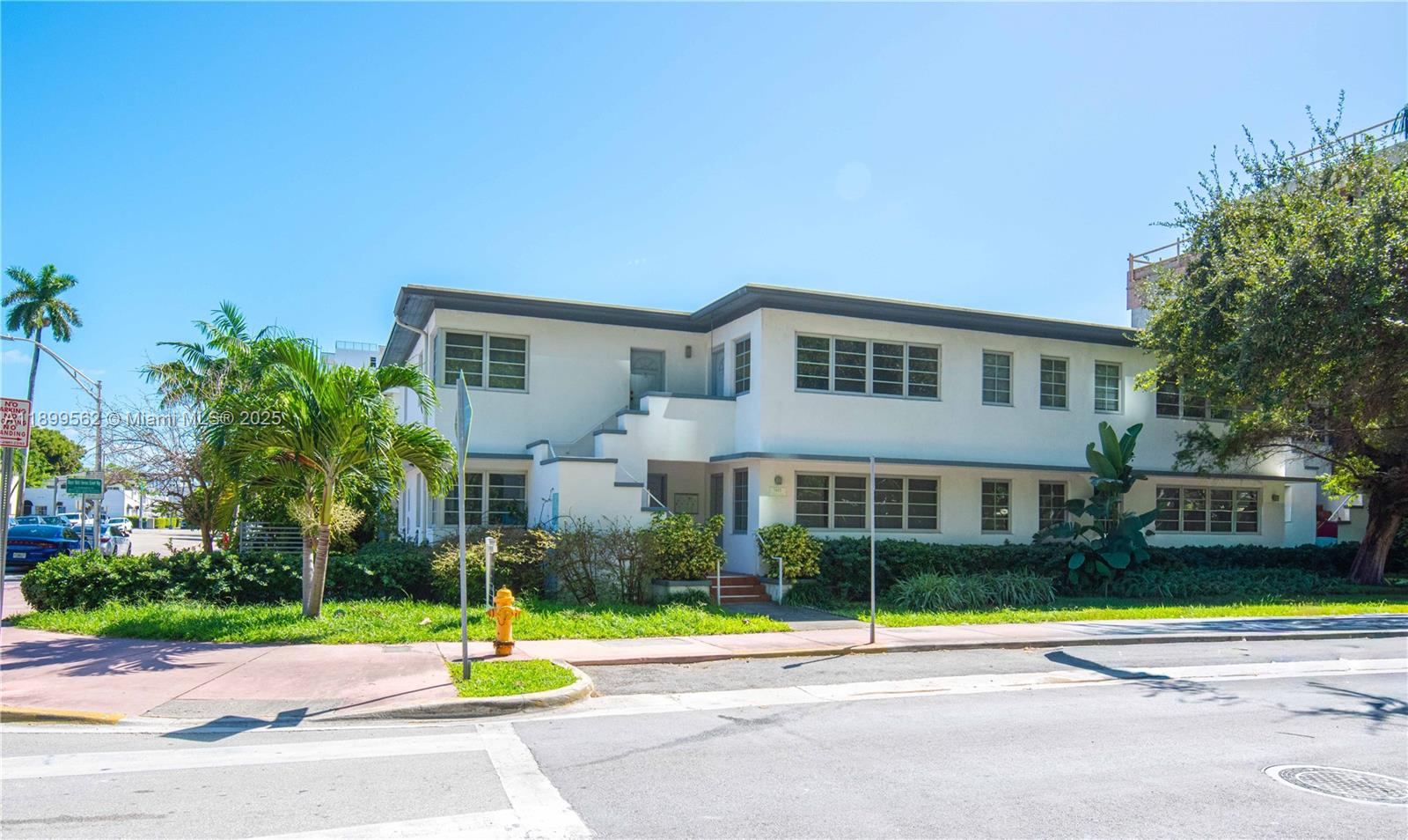 A two-story white apartment building with an exterior staircase and surrounding landscaping — 1485 Bay Rd, Miami Beach FL 33139, MIAMI BEACH, FL