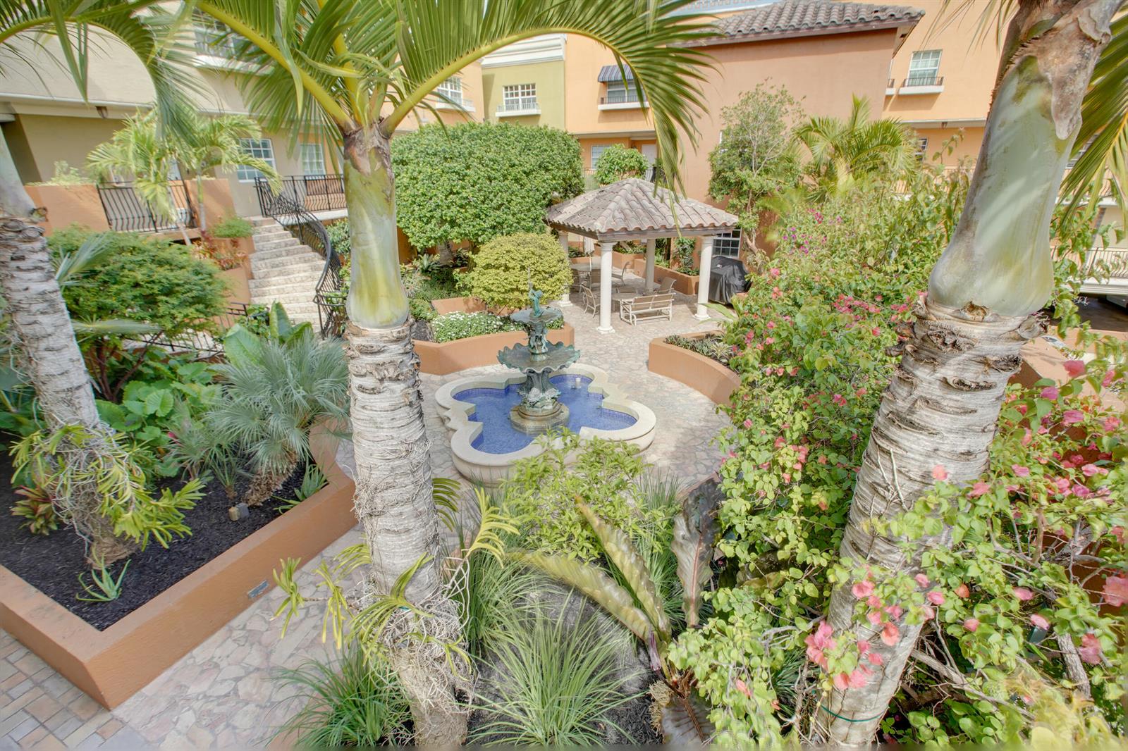 An elevated view of a courtyard featuring a central fountain, palm trees, and a gazebo — 1111 E Las Olas Boulevard # 410, Fort Lauderdale FL 33301, FORT LAUDERDALE, FL
