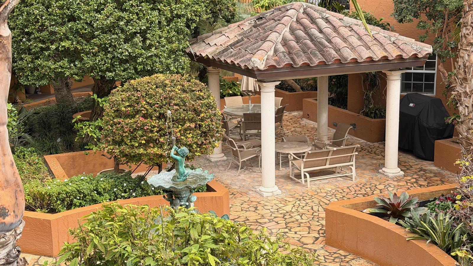 An outdoor patio features a tiled gazebo, a decorative fountain, and surrounding garden planters — 1111 E Las Olas Boulevard # 410, Fort Lauderdale FL 33301, FORT LAUDERDALE, FL