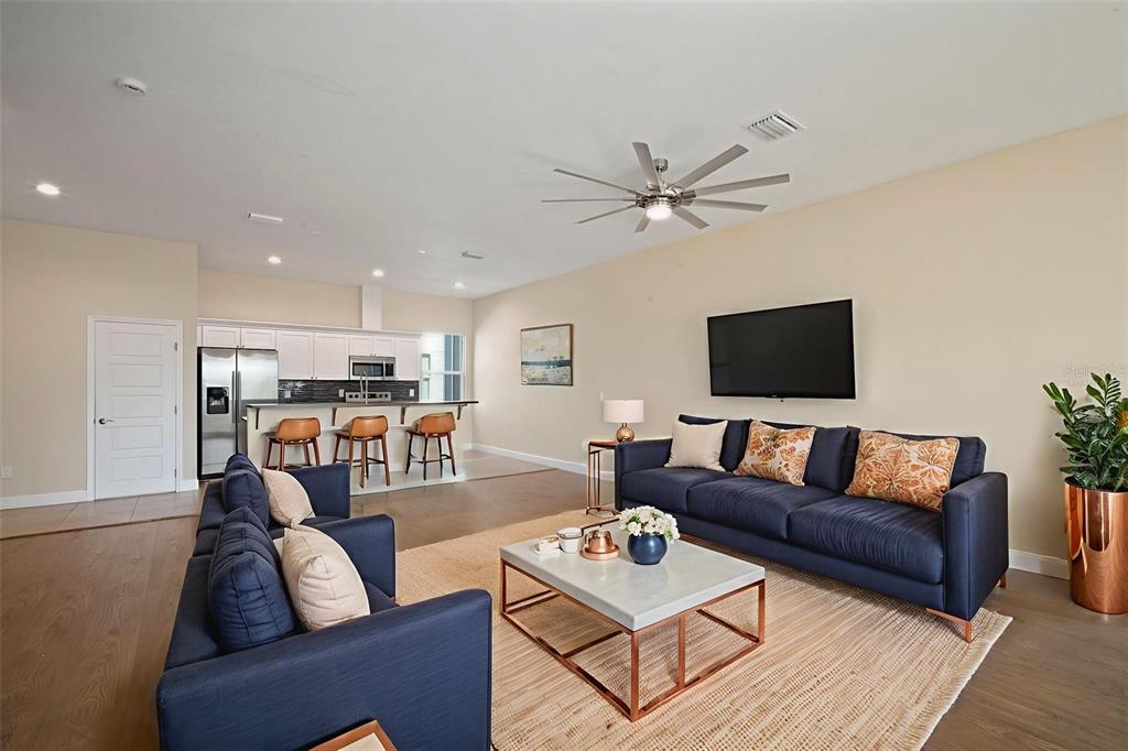 A living room with a blue sofa, coffee table, and an open kitchen with bar stools — 718 S 22ND STREET, TAMPA, FL