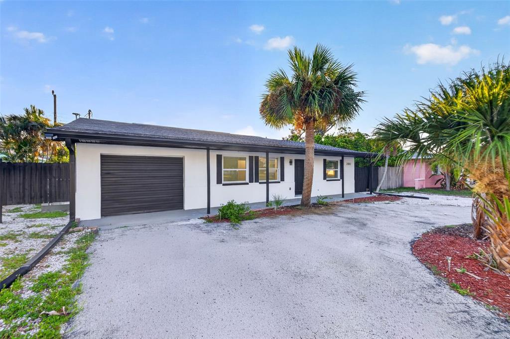 A single-story house with a white exterior, dark trim, a garage, and a palm tree — 2801 45TH STREET S, ST PETERSBURG, FL
