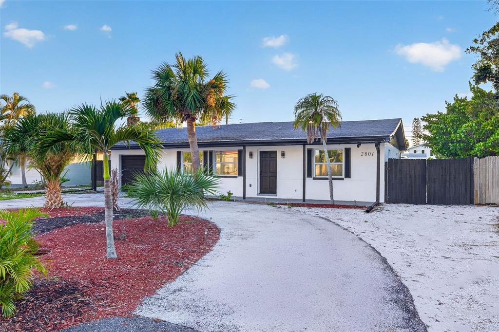 A single-story white house with a dark roof and a curved driveway with palm trees — 2801 45TH STREET S, ST PETERSBURG, FL