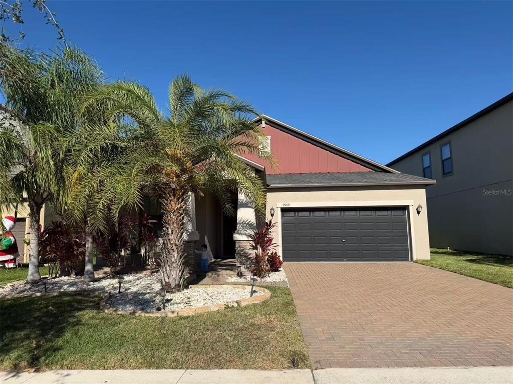 A single-story house with a brick paver driveway, a two-car garage, and a palm tree — 9909 VICTORY GALLOP LOOP, RUSKIN, FL