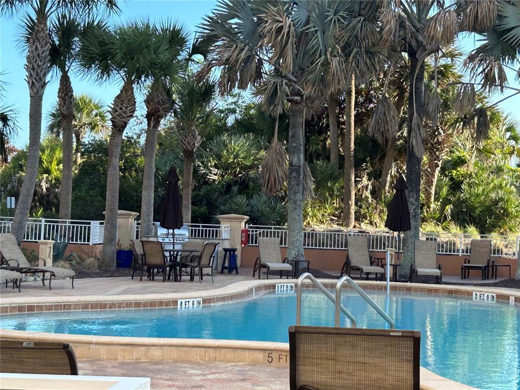 An open living area features tile flooring, two ceiling fans, and a sliding glass door — 261 MINORCA BEACH WAY UNIT 203, NEW SMYRNA BEACH, FL