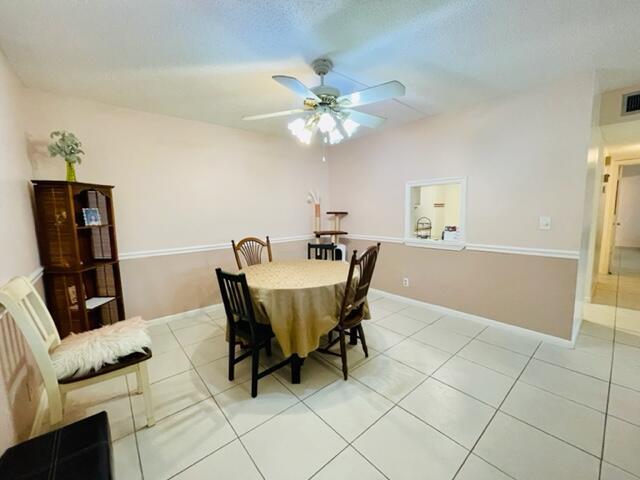 A dining room with a round table, four chairs, a ceiling fan, and tiled floors — 22755 SW 66th Avenue # 103, Boca Raton FL 33428, BOCA RATON, FL