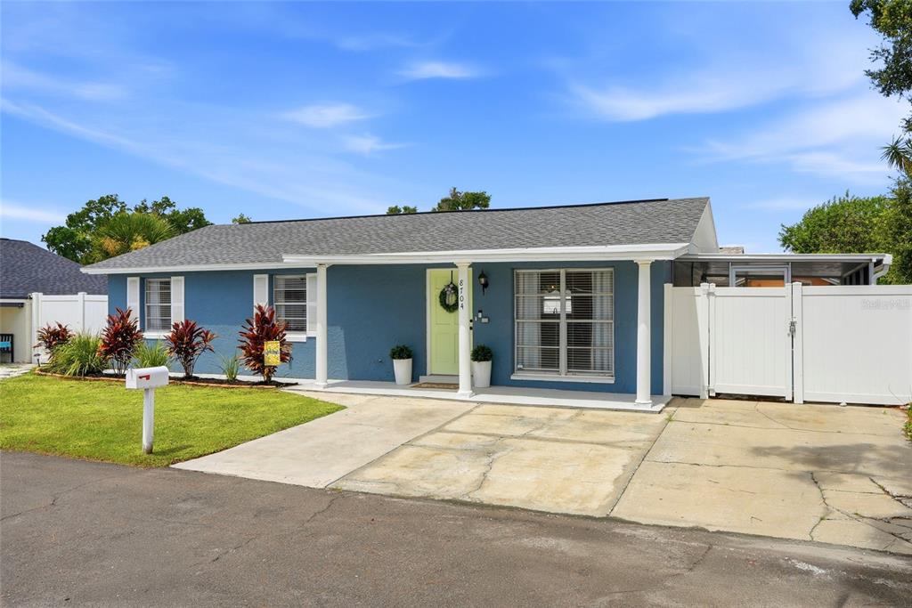 An open-concept living room with vaulted ceilings, gray walls, and wood-look flooring — 8704 MARLIN COURT, TAMPA, FL