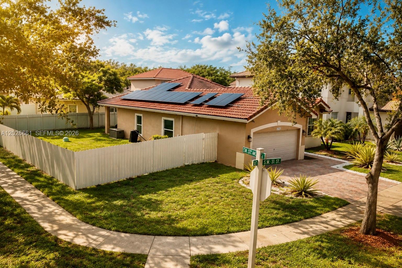 A single-story house with a tiled roof, solar panels, and a white fence — 13704 SW 31st St, Miramar FL 33027, MIRAMAR, FL