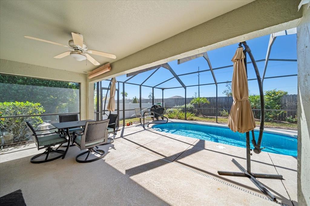 A covered patio features a dining set, a ceiling fan, and a screened-in swimming pool — 364 LAKE SUZANNE DRIVE, LAKE WALES, FL