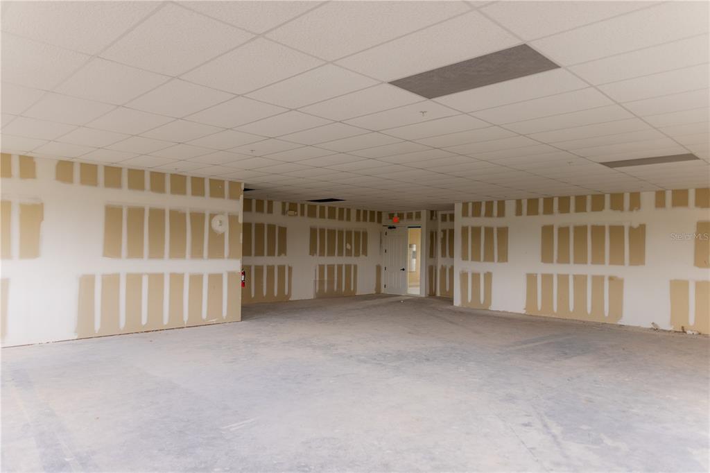 An unfinished commercial space features drywall panels, a drop ceiling, and a concrete floor — 5920 PAN AMERICAN BOULEVARD UNIT 309, NORTH PORT, FL