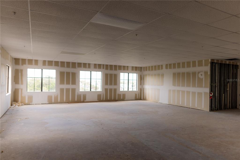 An unfinished commercial office space features drywall, a drop ceiling, and three exterior windows — 5920 PAN AMERICAN BOULEVARD UNIT 309, NORTH PORT, FL