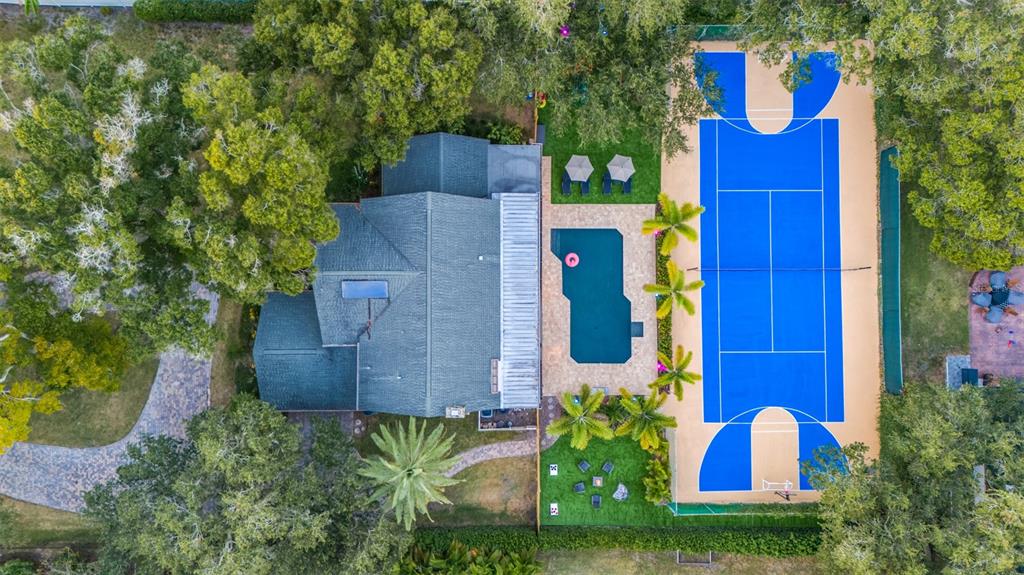An aerial view shows a house with a pool, patio, and a blue sports court — 7259 131ST STREET, SEMINOLE, FL
