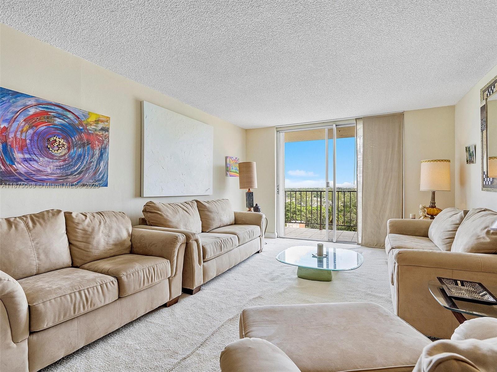 A living room features beige sofas, a glass coffee table, and a balcony with views — 1470 NE 125th Ter, North Miami FL 33161, NORTH MIAMI, FL
