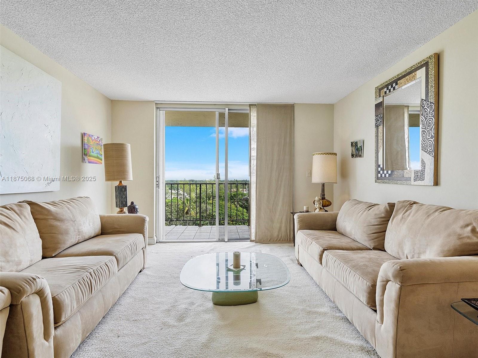 A living room features two beige sofas, a glass coffee table, and a balcony view — 1470 NE 125th Ter, North Miami FL 33161, NORTH MIAMI, FL