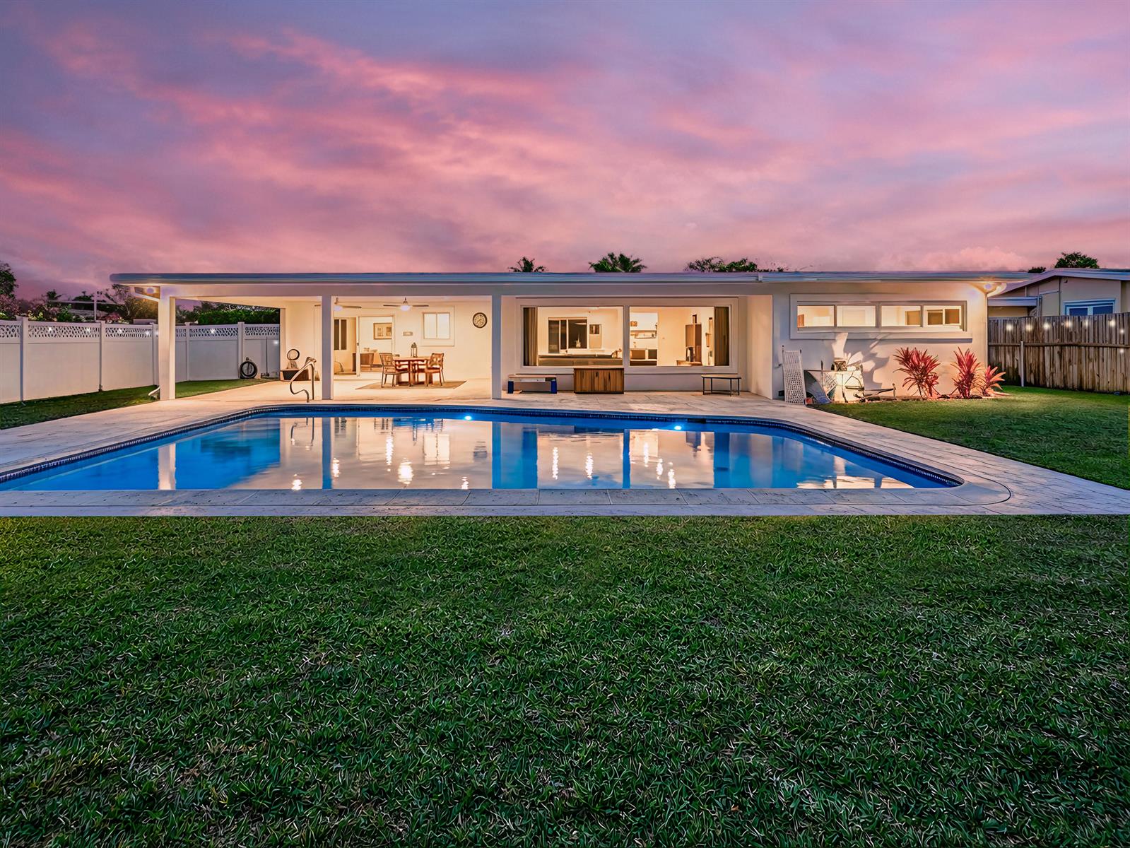A single-story house with a swimming pool and covered patio at sunset — 1098 W Camino Real, Boca Raton FL 33486, BOCA RATON, FL