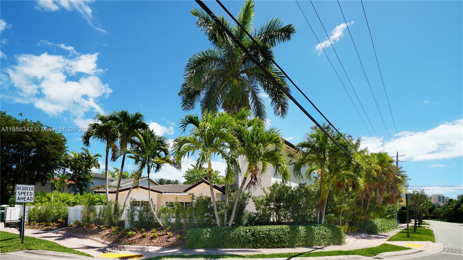 A single-story house with a white exterior is surrounded by palm trees and landscaping — 691 Ridgewood Rd, Key Biscayne FL 33149, KEY BISCAYNE, FL