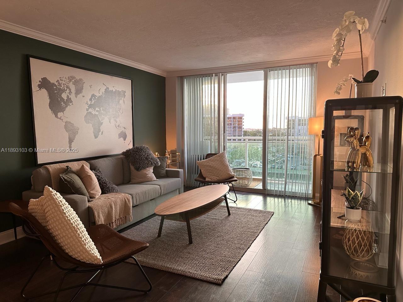 A living room features a grey sofa, a wooden coffee table, and a world map — 3000 S Ocean Dr # 612, Hollywood FL 33019, HOLLYWOOD, FL