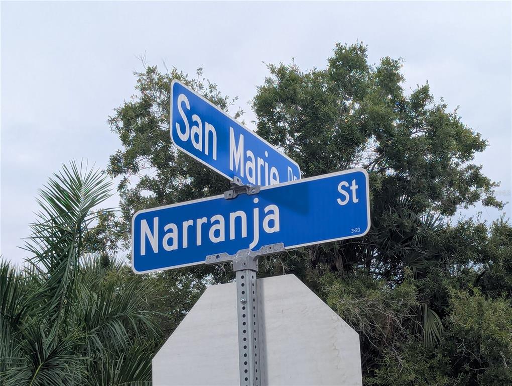 A blue street sign shows the intersection of San Maria and Naranja streets — 340 SAN MARIE DRIVE, PUNTA GORDA, FL