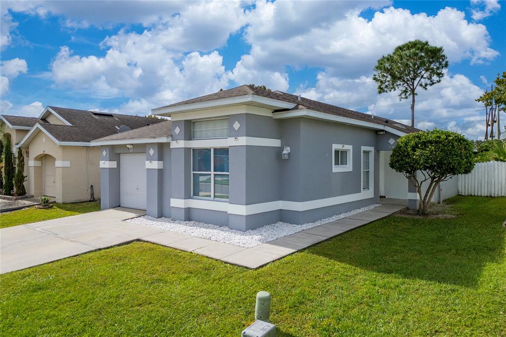 A gray single-story house with a white trim, a one-car garage, and a front lawn — 217 WOODBAY COURT, ORLANDO, FL