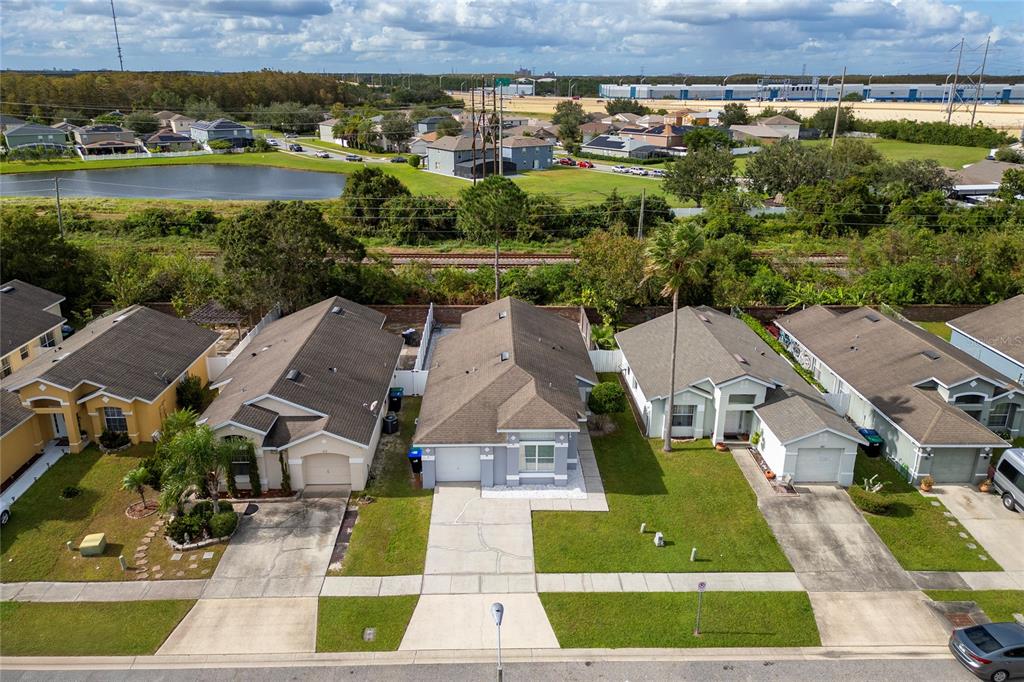 An aerial view shows a row of suburban houses with driveways and a nearby pond — 217 WOODBAY COURT, ORLANDO, FL