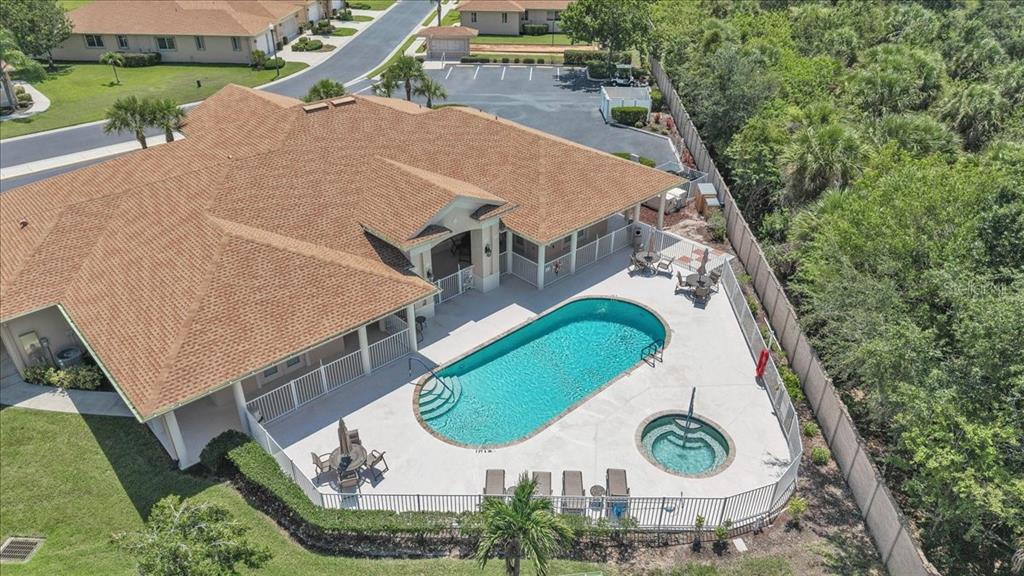 An aerial view shows a building with a swimming pool, hot tub, and patio area — 24057 PARK PLACE DRIVE S UNIT 51, PUNTA GORDA, FL