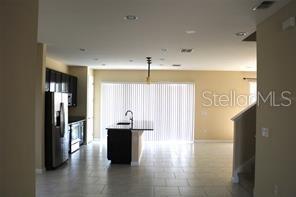 A kitchen with a central island and stainless steel appliances opens to a living area — 253 ALFORD DRIVE, DAVENPORT, FL