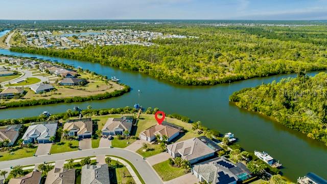 An aerial view shows a waterfront house with a red location pin in a neighborhood — 15080 SPANISH POINT DRIVE, PORT CHARLOTTE, FL