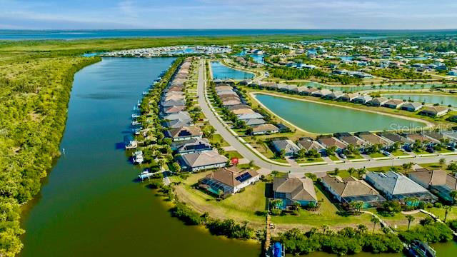 An aerial view of a waterfront residential neighborhood with houses, canals, and a large lake — 15080 SPANISH POINT DRIVE, PORT CHARLOTTE, FL