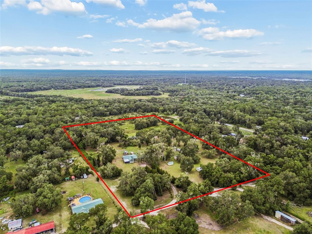 An aerial view shows a rural property outlined in red, featuring a house and outbuildings — 11094 SW 51ST DRIVE, WEBSTER, FL
