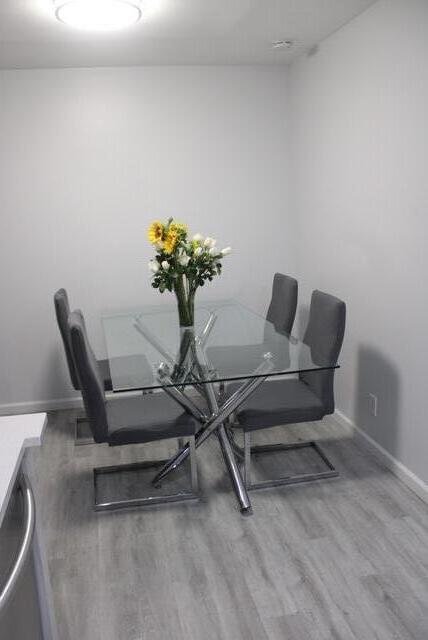 A dining area features a glass-topped table with four gray chairs on light wood flooring — 1803 Waterview Circle, Palm Springs FL 33461, PALM SPRINGS, FL