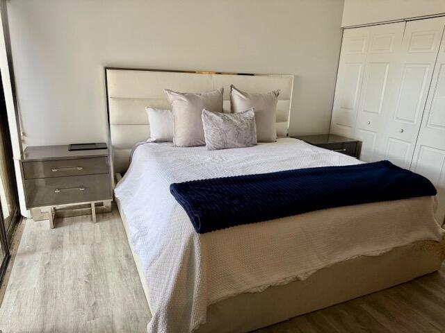 A bedroom features a white upholstered headboard, a bed with a navy throw, and nightstands — 1803 Waterview Circle, Palm Springs FL 33461, PALM SPRINGS, FL