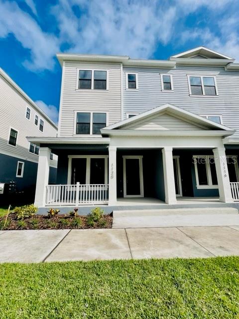 A three-story townhouse with light gray siding and a covered front porch — 1120 SPOTTED SANDPIPER LOOP, WINTER SPRINGS, FL