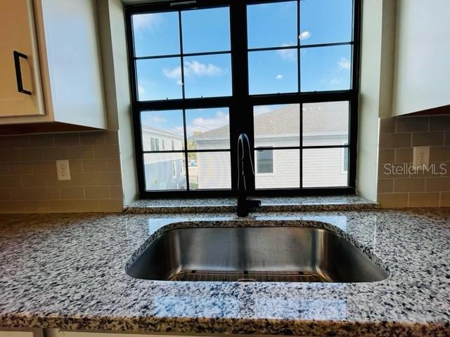 A kitchen sink with a dark faucet is centered in front of a grid window — 1120 SPOTTED SANDPIPER LOOP, WINTER SPRINGS, FL