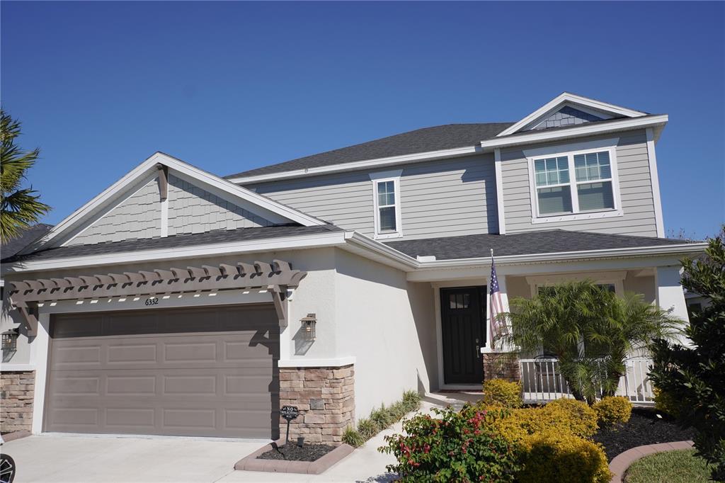 A two-story house with a gray exterior, a brown garage door, and a front porch — 6332 LAURELCREST GLEN, PALMETTO, FL