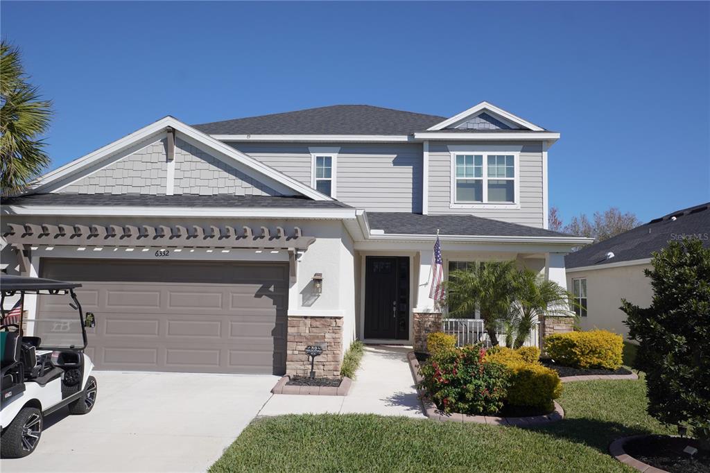 A two-story suburban house features a gray exterior, a two-car garage, and a front porch — 6332 LAURELCREST GLEN, PALMETTO, FL